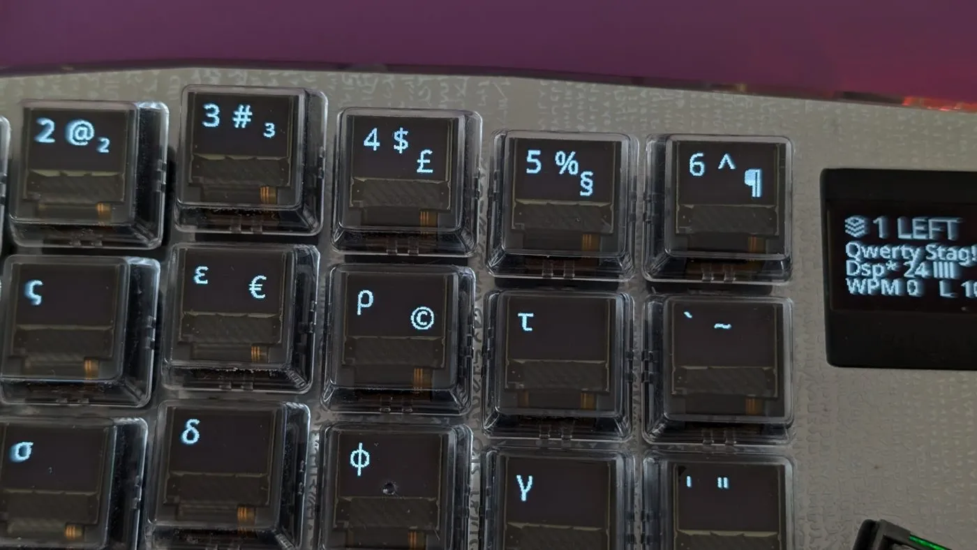 Keycap OLEDs rendering Greek letters β sigma, epsilon, rho, tau, delta, phi β alongside the status display