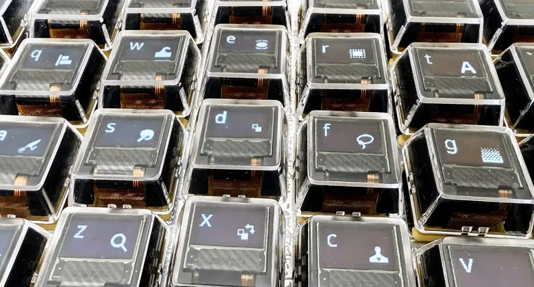 The per-key OLEDs showing app shortcut icons in the bottom-right of each key, next to the key's letter in the top-left